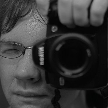 Close-up of a man and his camera while taking a photo