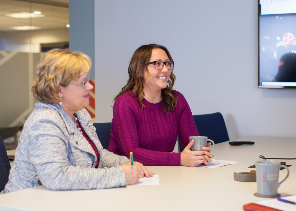 Two women sitting at a conference table