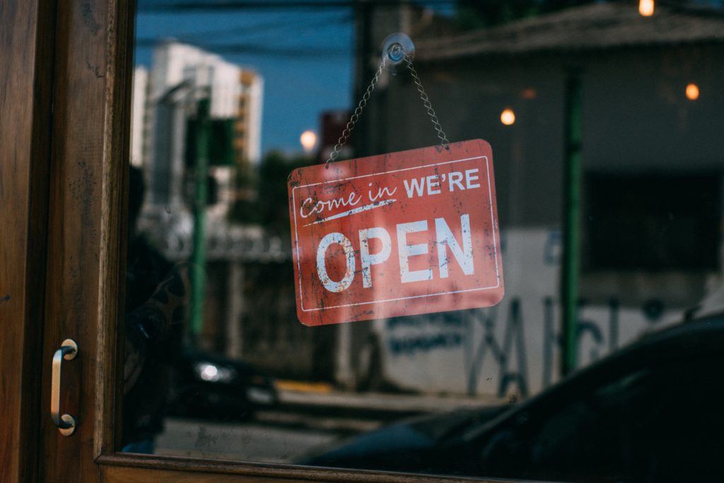 A red sign handing from the inside of a door that says "open"