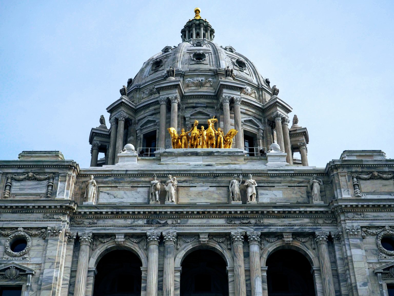 The top of the Minnesota Capitol main entrance showing gold horses