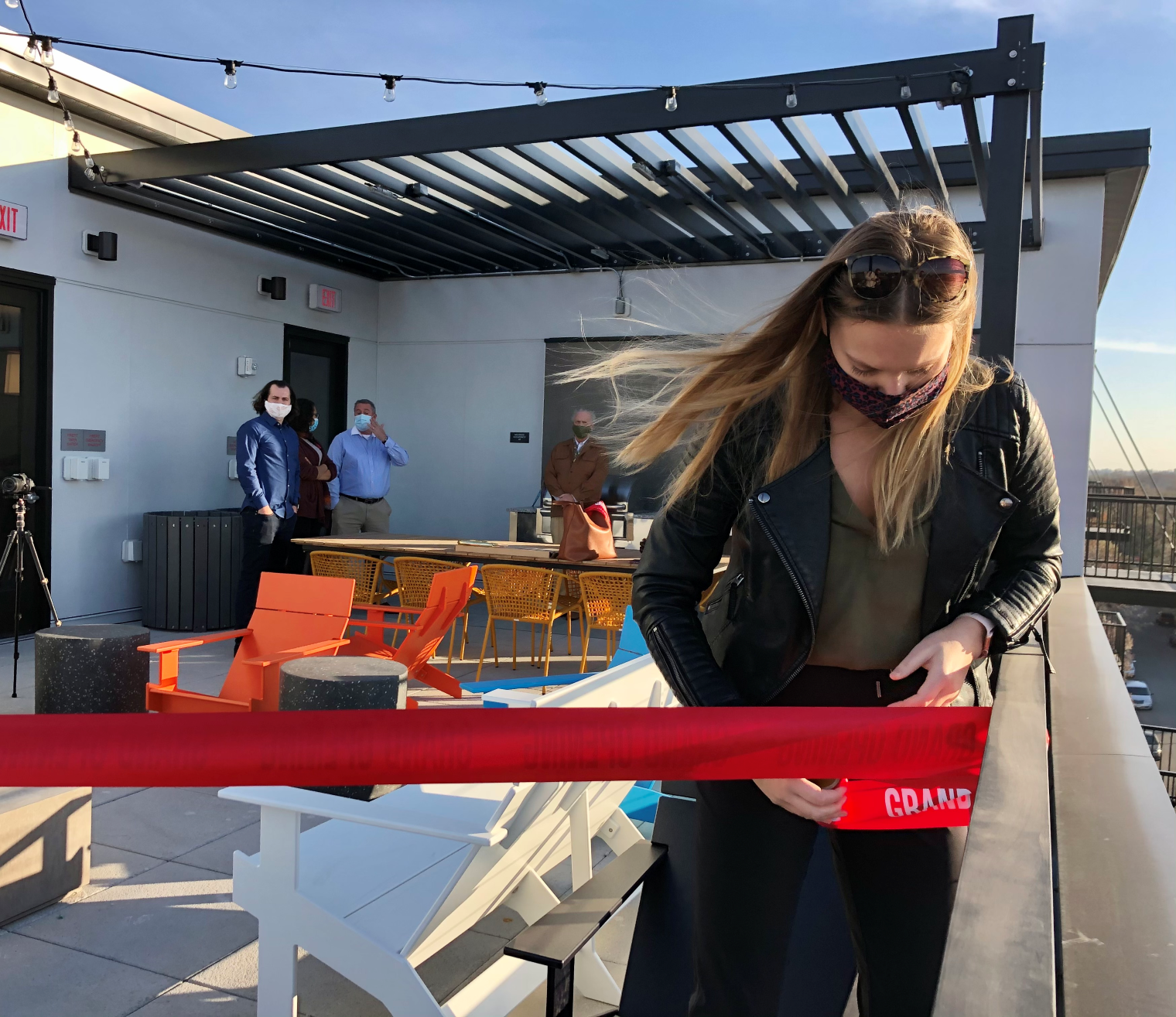 Woman standing on a rooftop setting up a ribbon