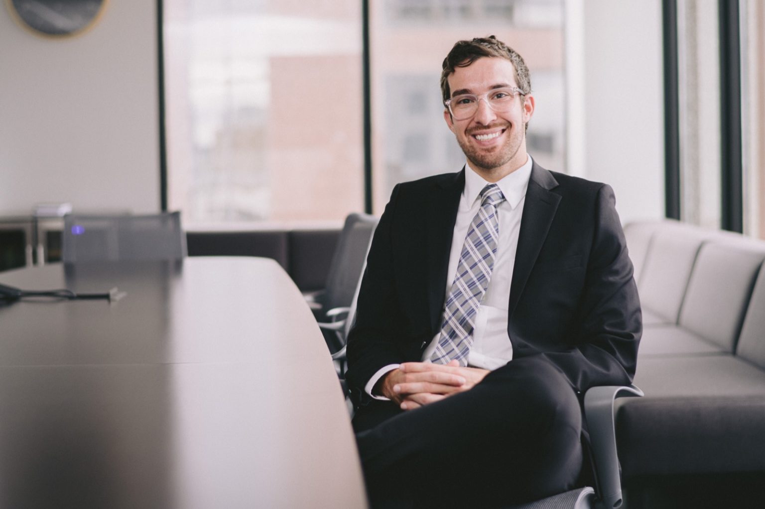 Andrew Hasek sitting in chair at conference table