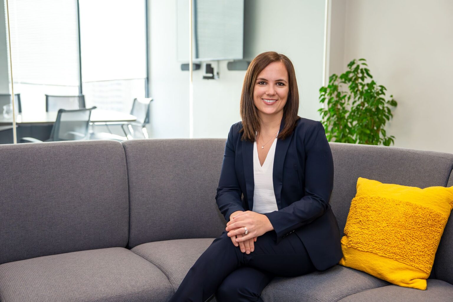 Sara Swenson smiling while sitting on a couch