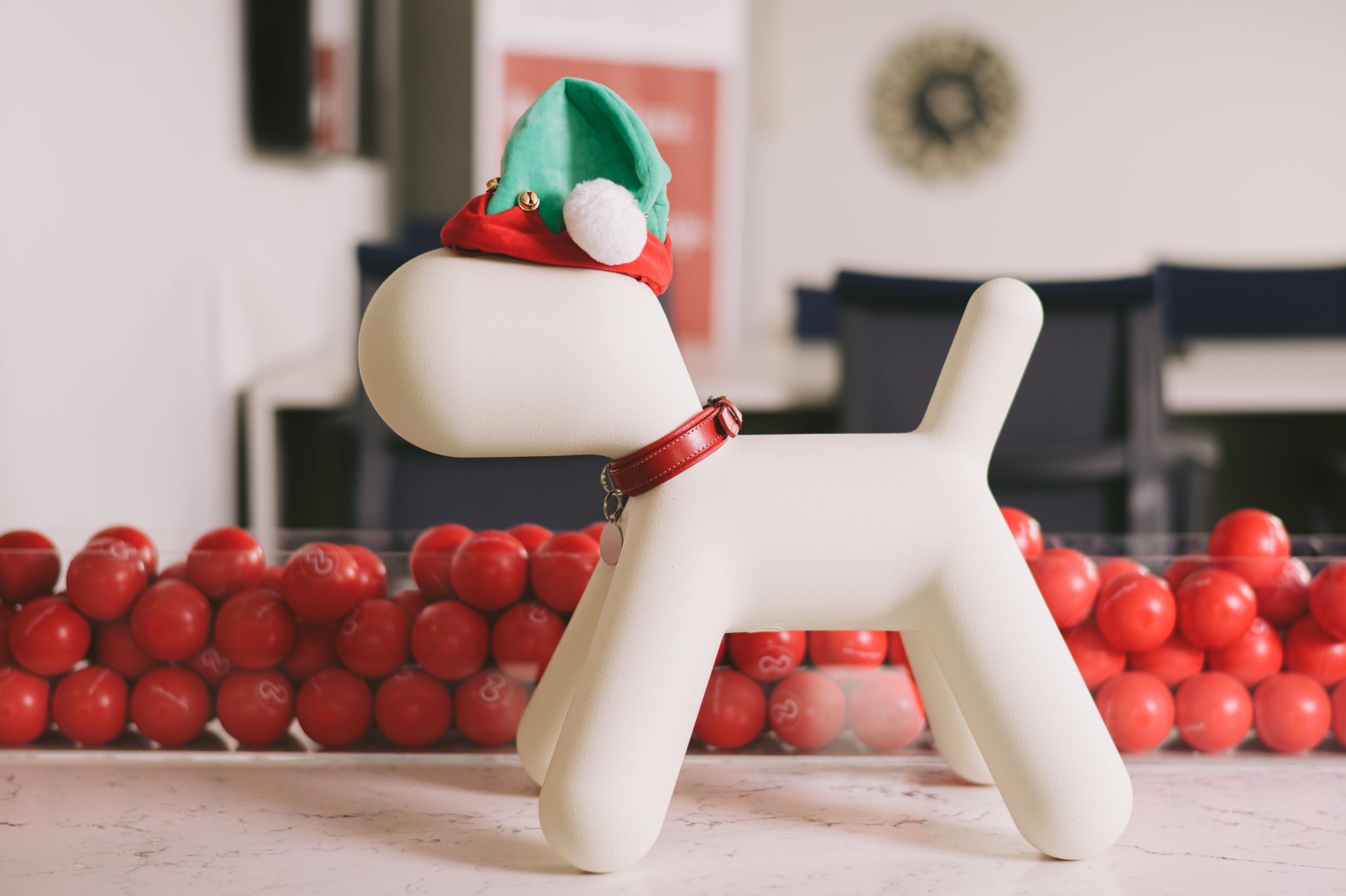 Dog statue wearing Santa hat and collar