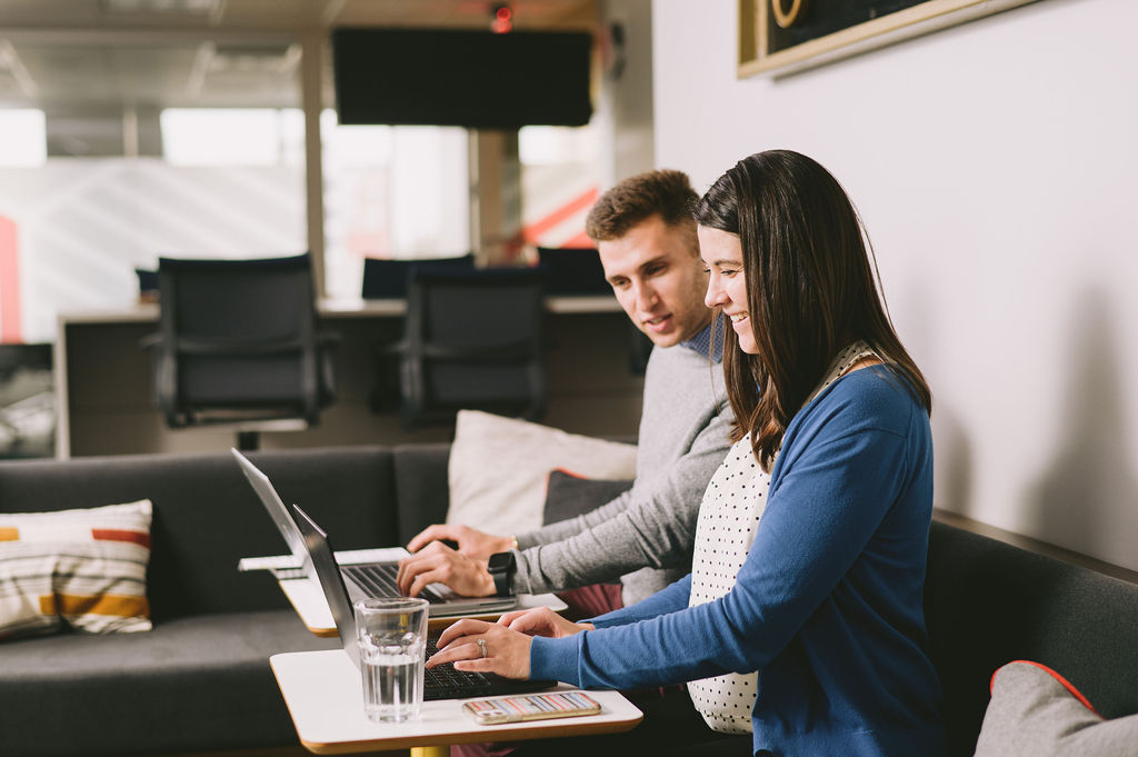 Two Goff Public team members sit in front of two computers