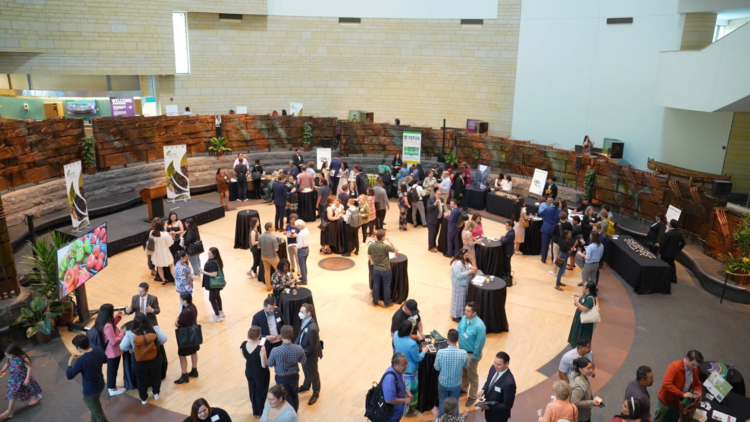 A group event with people and tables in a large rotunda.