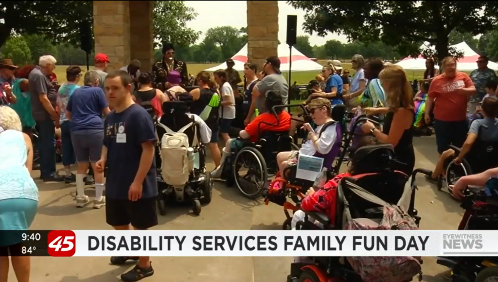 A news clip screenshot of a group gathering for the Disability services family fun day with people of various abilities