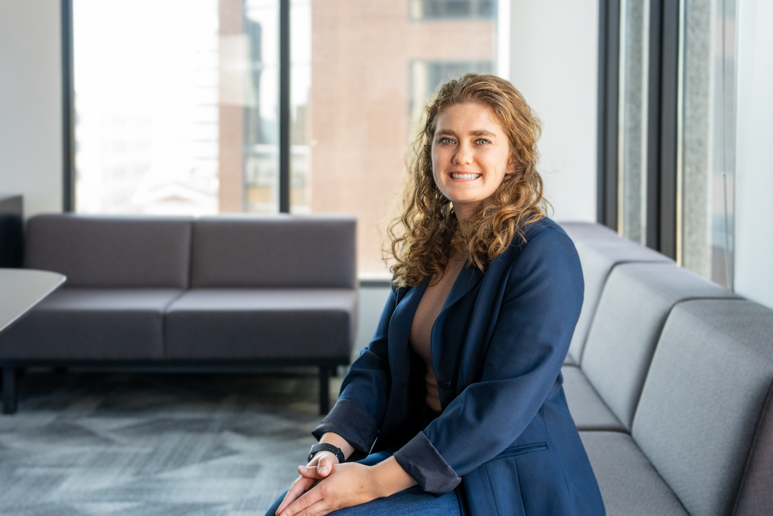 A white woman seated in a conference room.