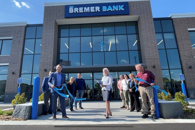 A group of individuals cuts a large ribbon outside of a new Bremer Bank Location