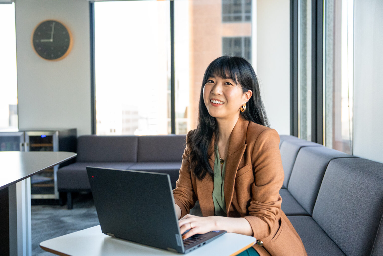 A professional sitting in a conference room in front of a computer