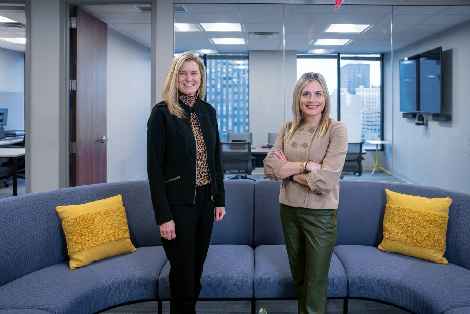 Two female business professionals standing in the lobby of new office space
