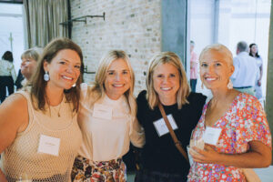 Four women pose for a picture at a party.