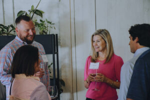 Four professionals talk at a party