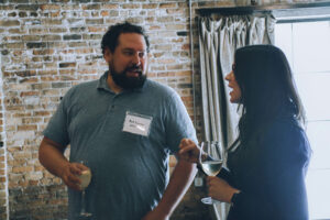 Three professionals talk at a party.