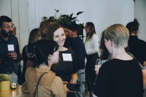 Three professionals talk at a party.