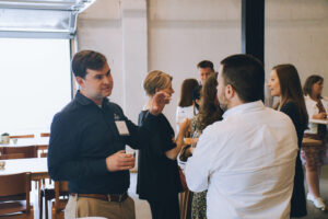 A pair of men talk at a party.