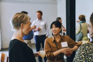 Two professional women talk at a party.