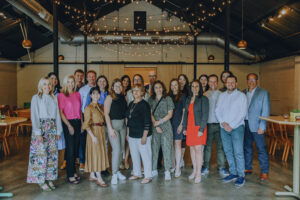 A large group of people pose for a photo in an event space.