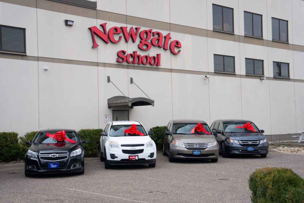 Cars with red bows parked in front of the Newgate School building