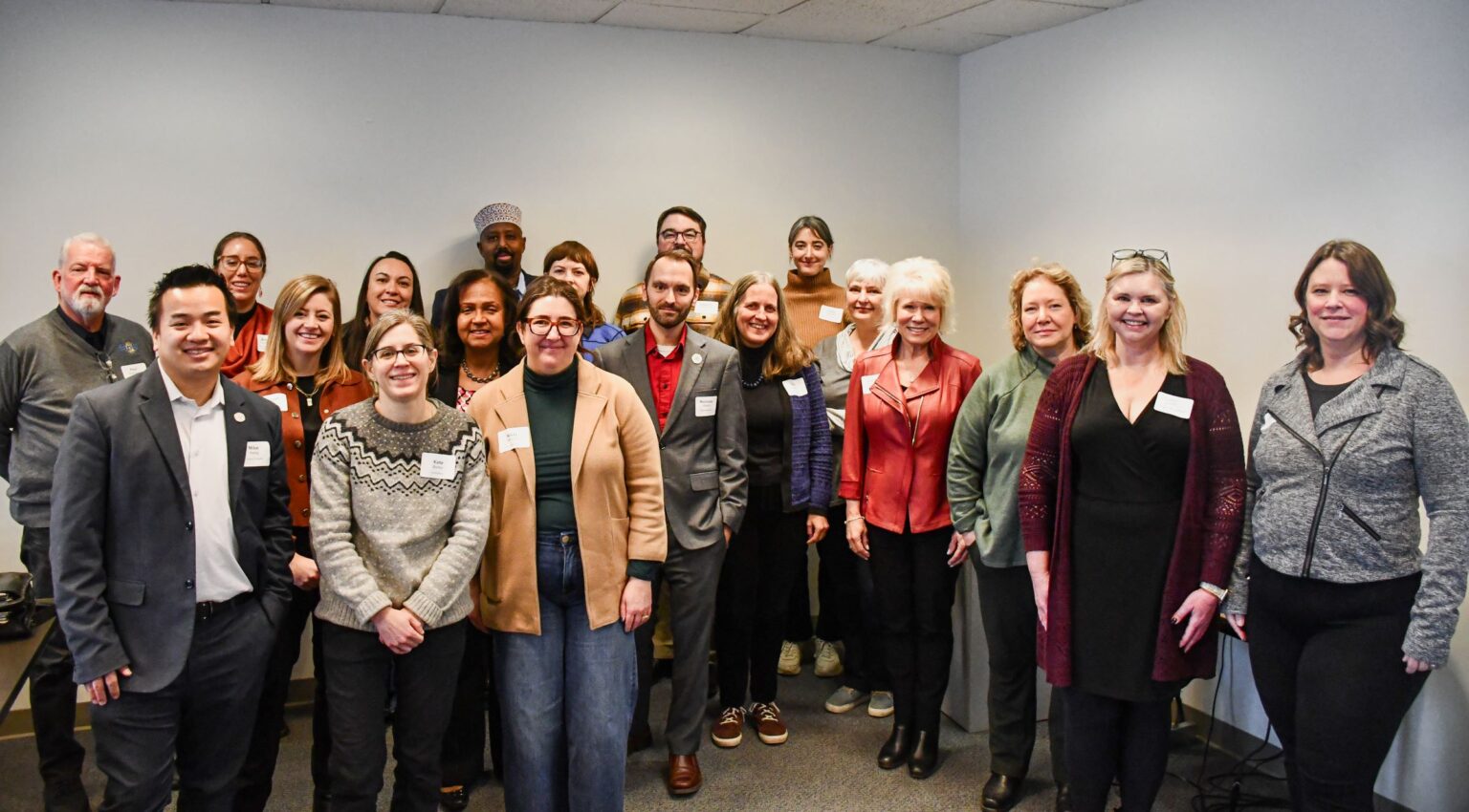 A group of people pose for a photo in a conference room