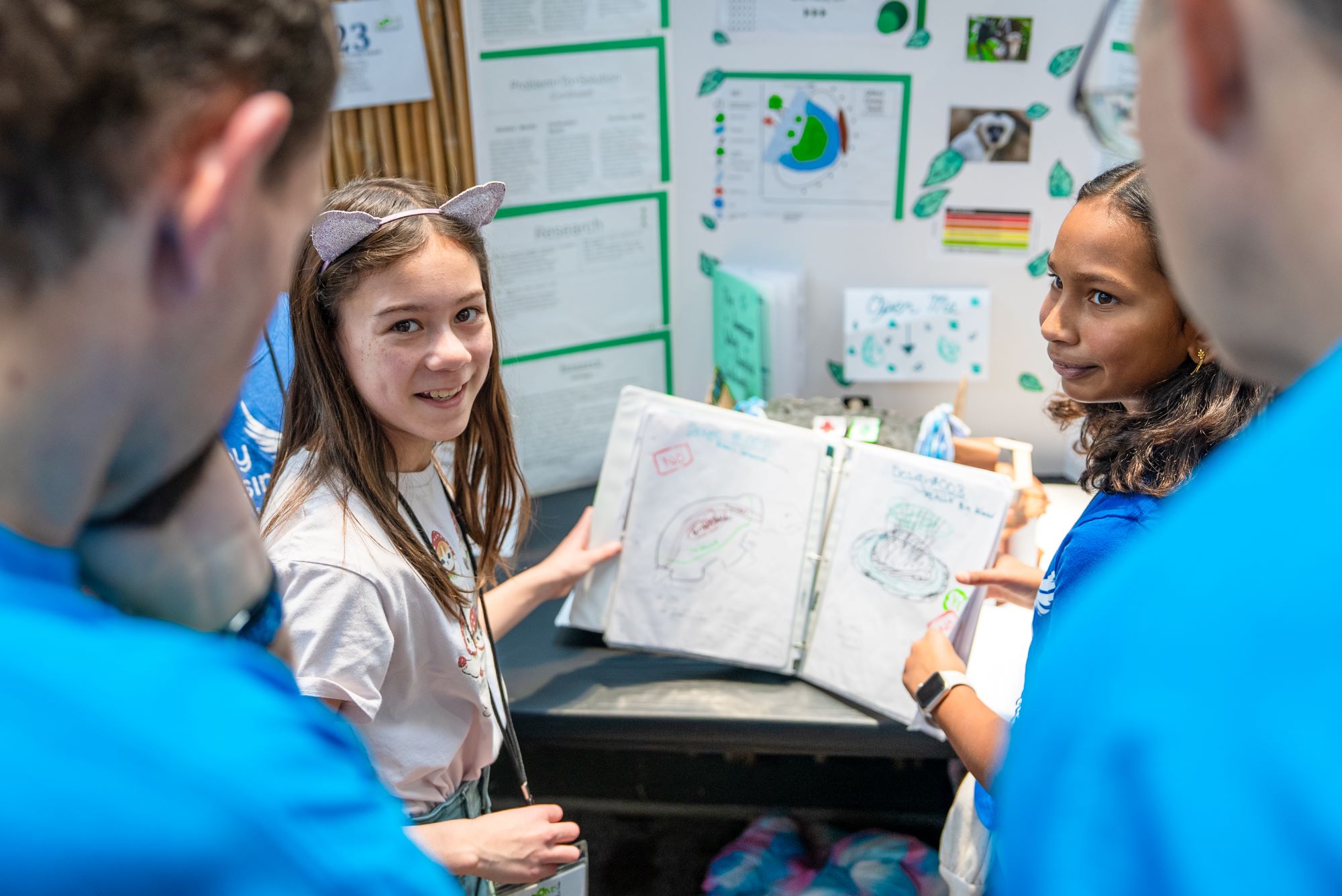 A student shows a science project to onlookers