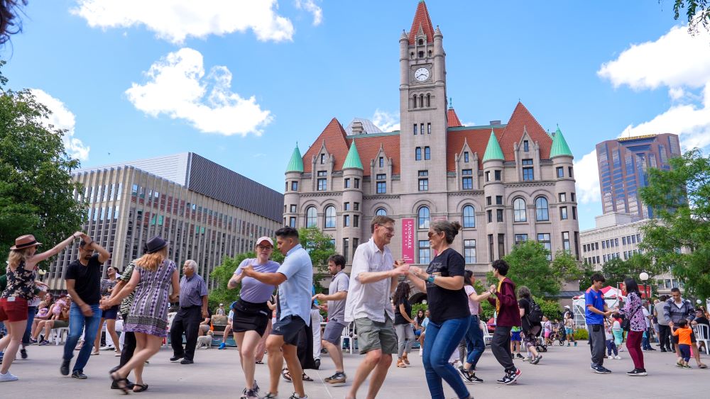 A group of people salsa dance in Rice Park in downtown Saint Paul.