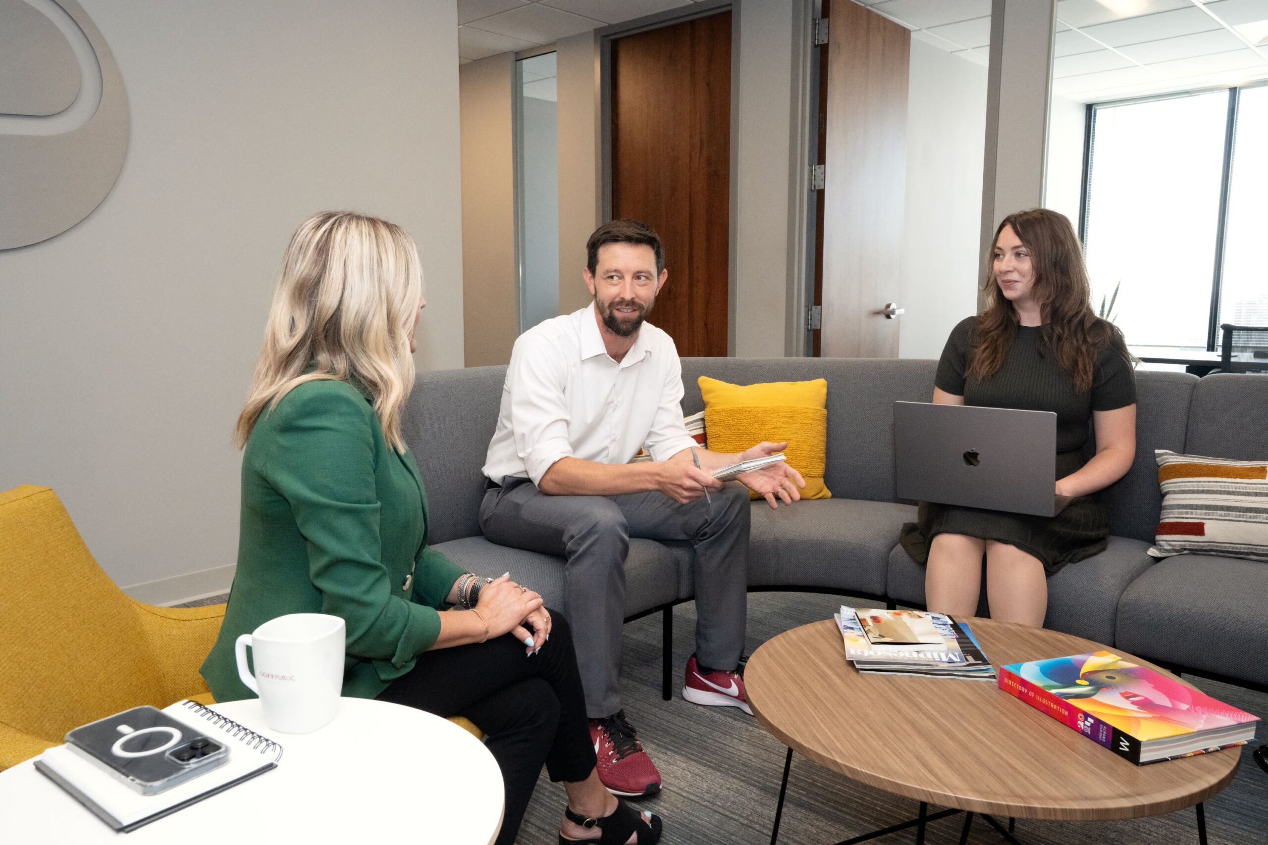 Three Goff Public employees talking sitting on a couch and a chair